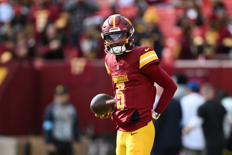 Washington Commanders quarterback Jayden Daniels (5) looks on during pre-game warm-ups before an NFL football game against the Dallas Cowboys, Sunday, Nov. 24, 2024, in Landover, Md. (AP Photo/Terrance Williams)