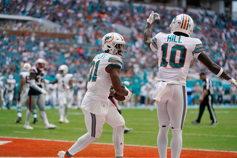 Miami Dolphins running back Raheem Mostert (31) catches the ball for a touchdown during the second half of an NFL football game against the New England Patriots, Sunday, Oct. 29, 2023, in Miami Gardens, Fla. (AP Photo/Lynne Sladky)