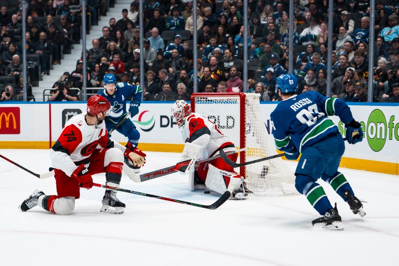 Mar 4, 2026; Vancouver, British Columbia, CAN; Vancouver Canucks forward Brock Boeser (6) and Carolina Hurricanes defenseman Jaccob Slavin (74) watch as forward Marco Rossi (93) scores on goalie Brandon Bussi (32) in the first at Rogers Arena. Mandatory Credit: Bob Frid-Imagn Images