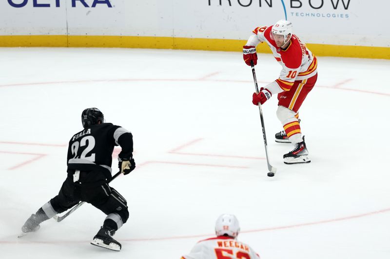 Dec 13, 2025; Los Angeles, California, USA;  Calgary Flames left wing Jonathan Huberdeau (10) passes the puck against Los Angeles Kings left wing Kevin Fiala (22) in overtime at Crypto.com Arena. Mandatory Credit: Kiyoshi Mio-Imagn Images
