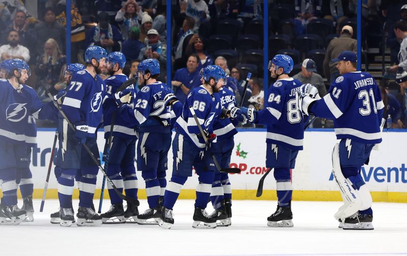 Dec 6, 2023; Tampa, Florida, USA; Nikita Kucherov (86), Tampa Bay Lightning left wing Tanner Jeannot (84) and teammates celebrate after they beat the Pittsburgh Penguins at Amalie Arena. Mandatory Credit: Kim Klement Neitzel-USA TODAY Sports