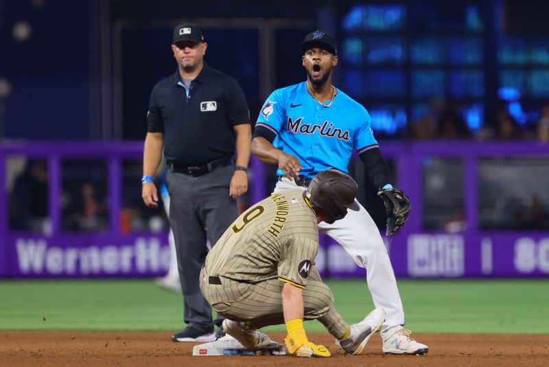 Aug 11, 2024; Miami, Florida, USA; Miami Marlins second baseman Otto Lopez (61) reacts after turning a double play as San Diego Padres second baseman Jake Cronenworth (9) slides into second base during the fourth inning at loanDepot Park. Mandatory Credit: Sam Navarro-USA TODAY Sports