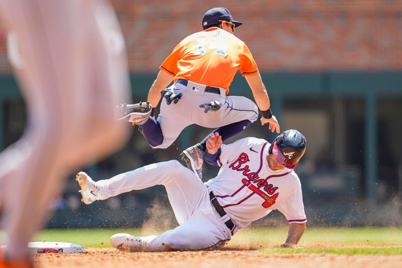 Apr 23, 2023; Cumberland, Georgia, USA; Atlanta Braves first baseman Matt Olson (28) takes out Houston Astros second baseman Mauricio Dubon (14) causing an error on a throw during the sixth inning at Truist Park. Mandatory Credit: Dale Zanine-USA TODAY Sports