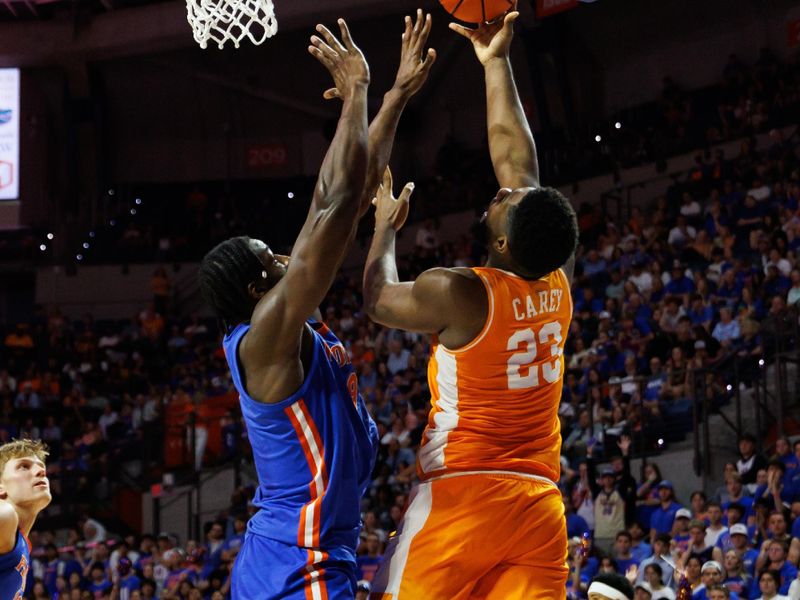 Jan 10, 2026; Gainesville, Florida, USA; Tennessee Volunteers forward Jaylen Carey (23) attempts a layup over Florida Gators center Rueben Chinyelu (9) during the first half at Exactech Arena at the Stephen C. O'Connell Center. Mandatory Credit: Matt Pendleton-Imagn Images