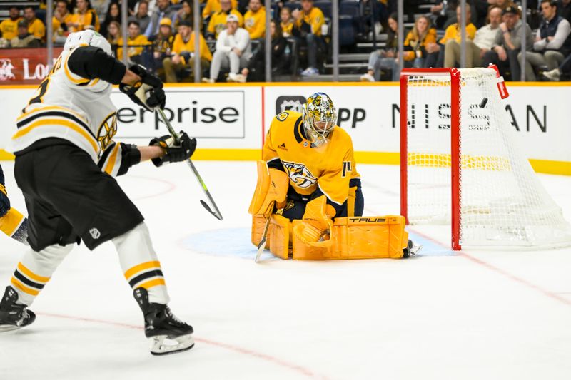 Oct 22, 2024; Nashville, Tennessee, USA; Nashville Predators goaltender Juuse Saros (74) blocks the shot of Boston Bruins center Elias Lindholm (28) during the second period at Bridgestone Arena. Mandatory Credit: Steve Roberts-Imagn Images