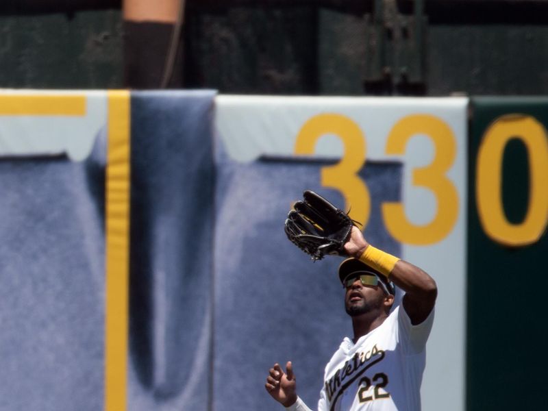 Jul 7, 2024; Oakland, California, USA; Oakland Athletics left fielder Miguel Andujar (22) makes the catch of a fly ball off the bat of Baltimore Orioles catcher Adley Rutschman during the second inning at Oakland-Alameda County Coliseum. Mandatory Credit: D. Ross Cameron-USA TODAY Sports