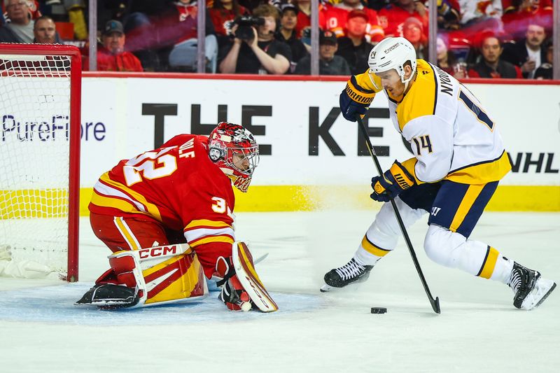 Nov 15, 2024; Calgary, Alberta, CAN; Calgary Flames goaltender Dustin Wolf (32) makes a save against Nashville Predators center Gustav Nyquist (14) during the first period at Scotiabank Saddledome. Mandatory Credit: Sergei Belski-Imagn Images