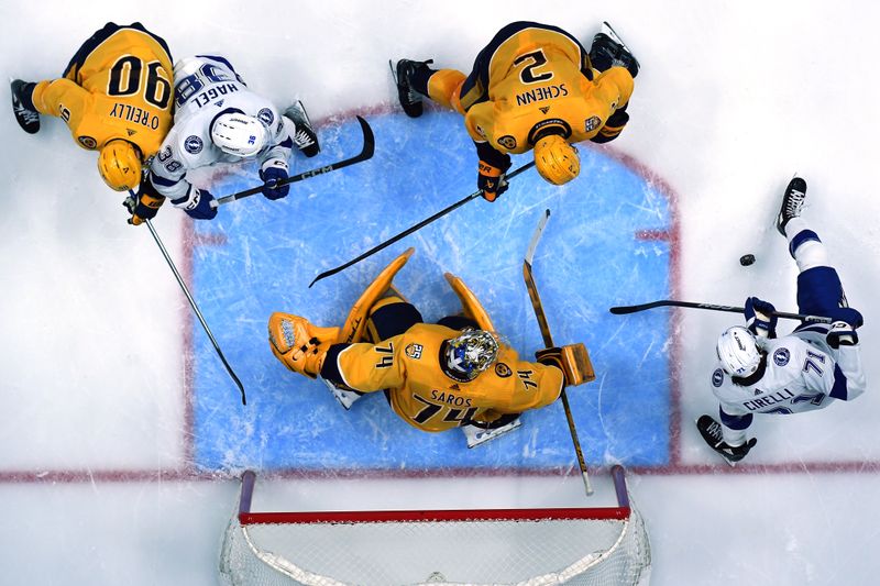 Dec 7, 2023; Nashville, Tennessee, USA; Tampa Bay Lightning center Anthony Cirelli (71) works to get a shot on Nashville Predators goaltender Juuse Saros (74) during the third period at Bridgestone Arena. Mandatory Credit: Christopher Hanewinckel-USA TODAY Sports