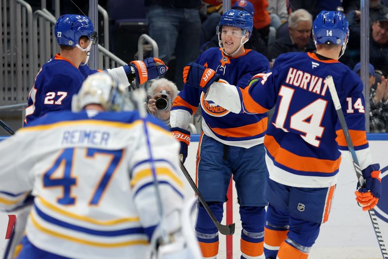 Nov 30, 2024; Elmont, New York, USA; New York Islanders right wing Simon Holmstrom (10) celebrates his goal against Buffalo Sabres goaltender James Reimer (47) with left wing Anders Lee (27) and center Bo Horvat (14) during the second period at UBS Arena. Mandatory Credit: Brad Penner-Imagn Images