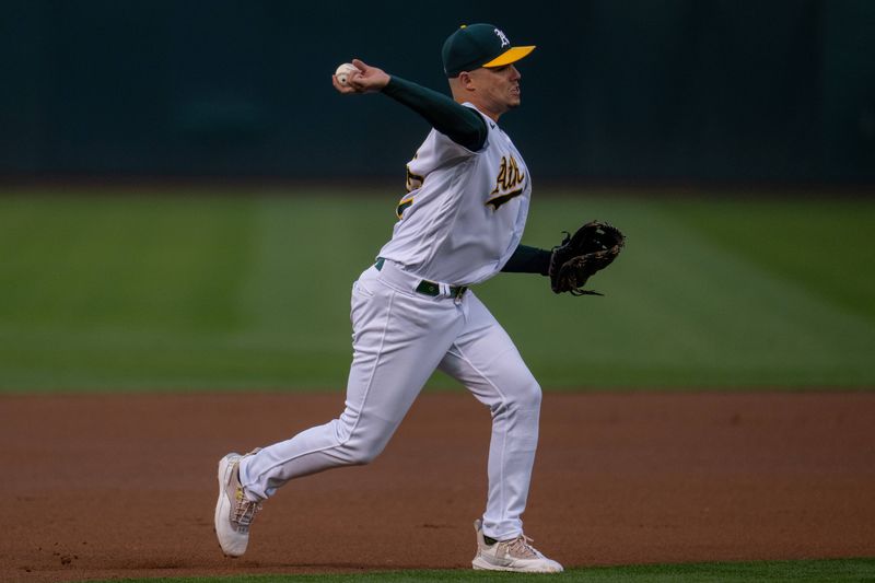 Sep 19, 2023; Oakland, California, USA; Oakland Athletics third baseman Aledmys Diaz (12) throws out Oakland Athletics catcher Carlos Perez (not pictured) during the first inning at Oakland-Alameda County Coliseum. Mandatory Credit: Neville E. Guard-USA TODAY Sports