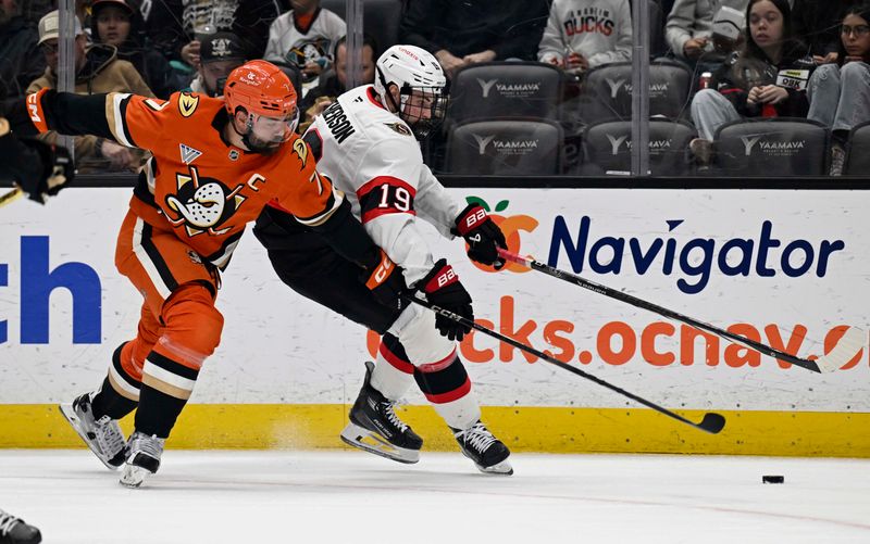 Dec 1, 2024; Anaheim, California, USA;  Anaheim Ducks defenseman Radko Gudas (7) vies for the puck with Ottawa Senators right wing Drake Batherson (19) during the first period at Honda Center. Mandatory Credit: Alex Gallardo-Imagn Images