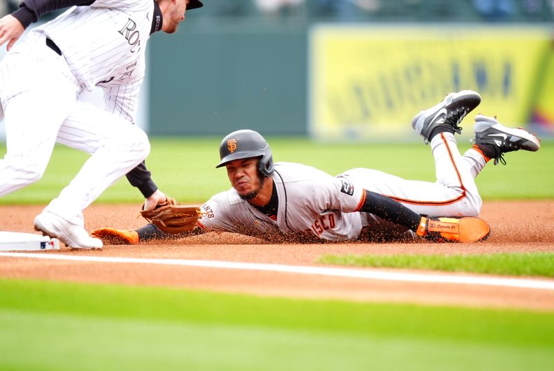 May 9, 2024; Denver, Colorado, USA; Colorado Rockies third baseman Ryan McMahon, left, tags out San Francisco Giants second baseman Thairo Estrada on a steal attempt in the first inning against the Colorado Rockies at Coors Field. Mandatory Credit: Ron Chenoy-USA TODAY Sports