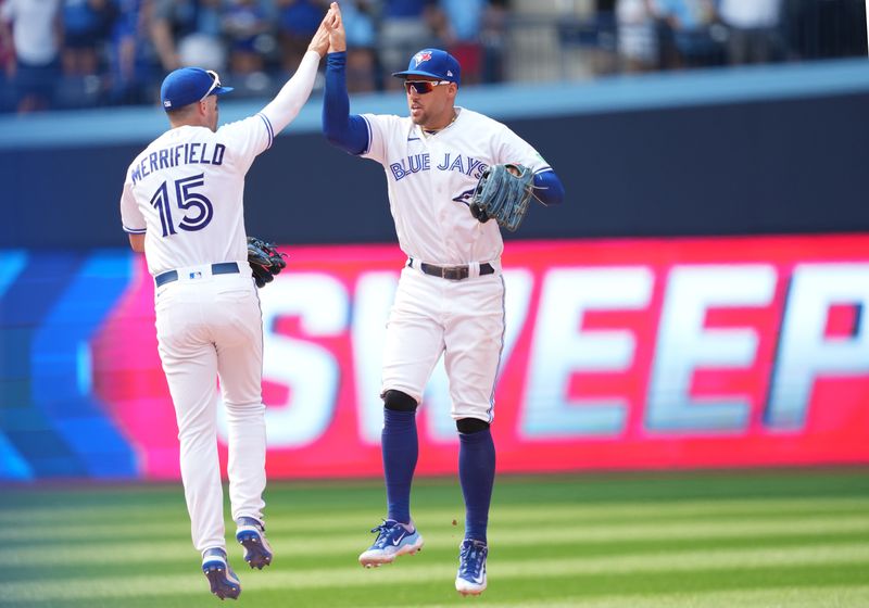 Jul 16, 2023; Toronto, Ontario, CAN; Toronto Blue Jays left fielder Whit Merrifield (15) and right fielder George Springer (4) celebrate the win at the end of the ninth inning against the Arizona Diamondbacks at Rogers Centre. Mandatory Credit: Nick Turchiaro-USA TODAY Sports