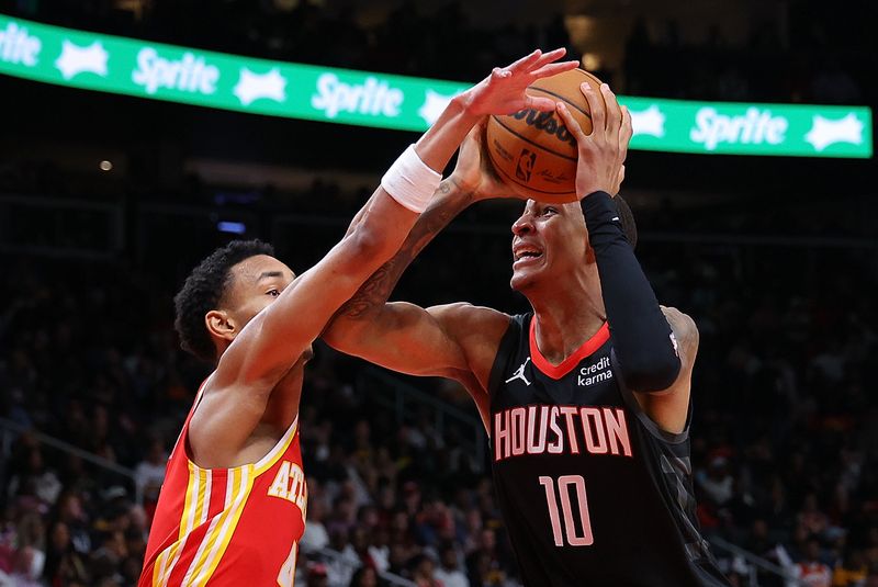 ATLANTA, GEORGIA - FEBRUARY 10:  Jabari Smith Jr. #10 of the Houston Rockets draws a foul as he drives against Kobe Bufkin #4 of the Atlanta Hawks during the fourth quarter at State Farm Arena on February 10, 2024 in Atlanta, Georgia.  NOTE TO USER: User expressly acknowledges and agrees that, by downloading and/or using this photograph, user is consenting to the terms and conditions of the Getty Images License Agreement.  (Photo by Kevin C. Cox/Getty Images)