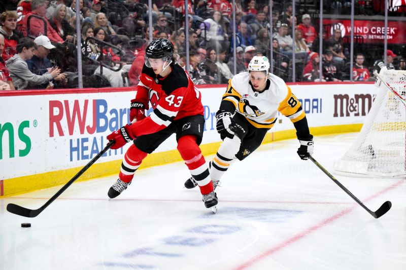 Nov 8, 2025; Newark, New Jersey, USA; New Jersey Devils defenseman Luke Hughes (43) skates with the puck while defended by Pittsburgh Penguins center Ben Kindel (81) during the first period at Prudential Center. Mandatory Credit: John Jones-Imagn Images