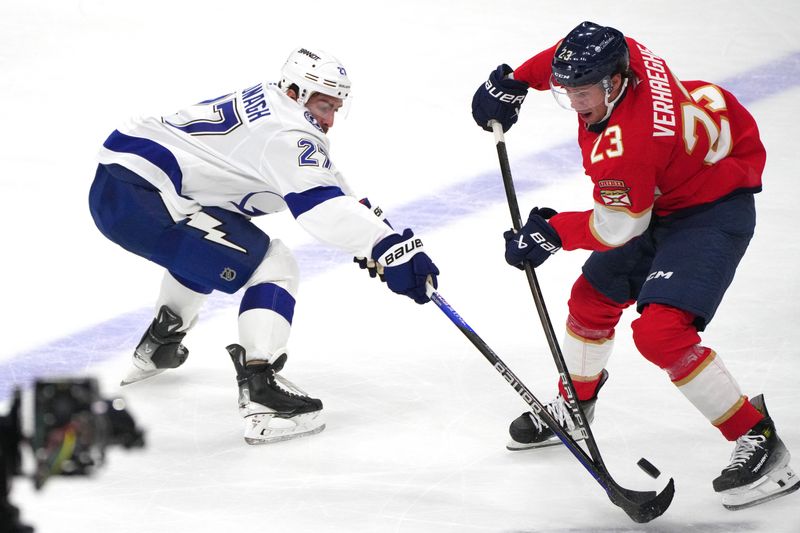 Sep 30, 2024; Sunrise, Florida, USA; Florida Panthers center Carter Verhaeghe (23) battles for possession with Tampa Bay Lightning defenseman Ryan McDonagh (27) during the third period at Amerant Bank Arena. Mandatory Credit: Jim Rassol-Imagn Images