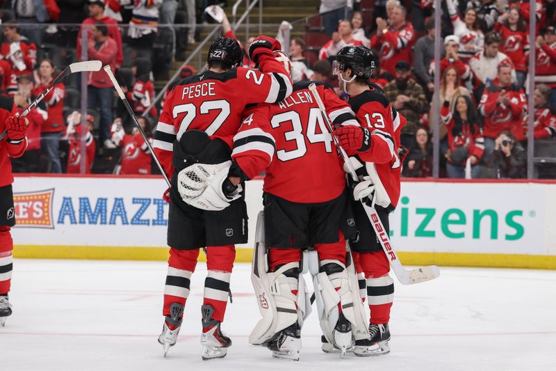 Oct 16, 2025; Newark, New Jersey, USA; New Jersey Devils center Nico Hischier (13), goaltender Jake Allen (34) and defenseman Brett Pesce (22) celebrate the Devils win over the Florida Panthers at Prudential Center. Mandatory Credit: Ed Mulholland-Imagn Images