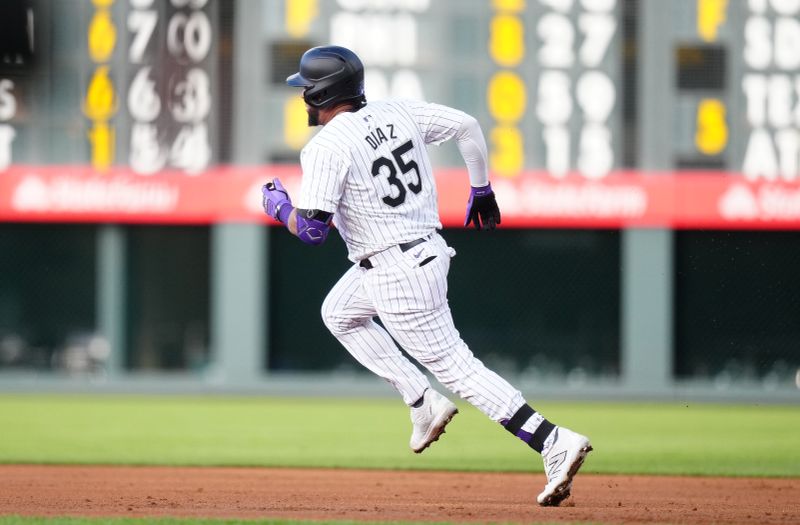 Apr 21, 2024; Denver, Colorado, USA; Colorado Rockies catcher Elias Díaz (35) runs out a two run double in the first inning against the Seattle Mariners at Coors Field. Mandatory Credit: Ron Chenoy-USA TODAY Sports