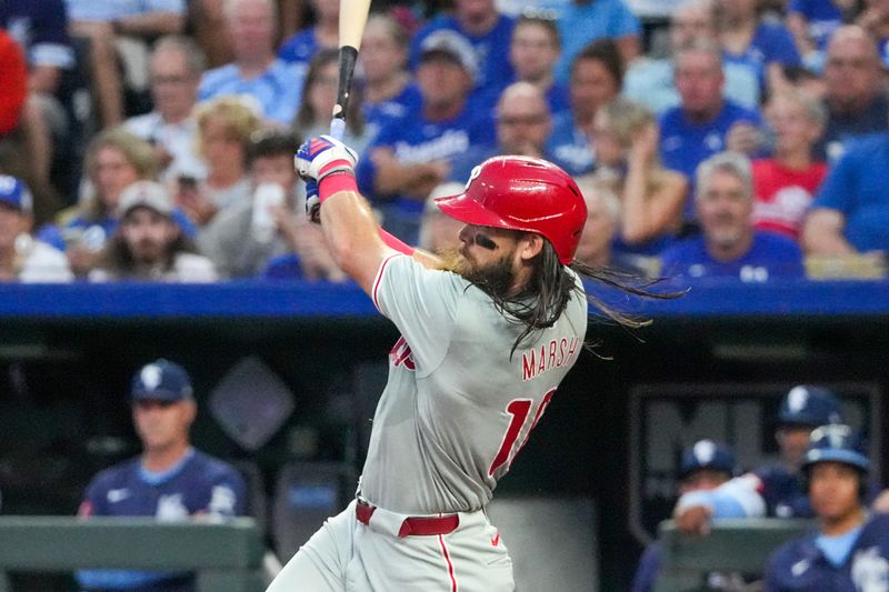 Aug 23, 2024; Kansas City, Missouri, USA; Philadelphia Phillies designated hitter Kyle Schwarber (12) hits a one run single against the Kansas City Royals in the third inning at Kauffman Stadium. Mandatory Credit: Denny Medley-USA TODAY Sports