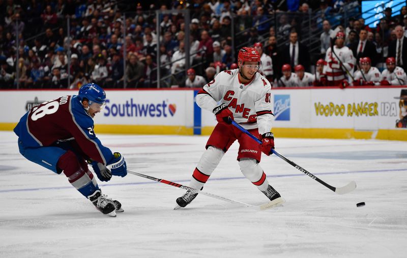 Oct 21, 2023; Denver, Colorado, USA; Carolina Hurricanes center Jesperi Kotkaniemi (82) takes control of the puck away from Colorado Avalanche left wing Miles Wood (28) in the first period at Ball Arena. Mandatory Credit: John Leyba-USA TODAY Sports