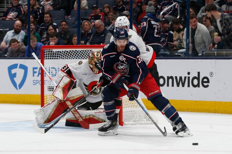 Apr 8, 2025; Columbus, Ohio, USA; Columbus Blue Jackets center Boone Jenner (38) passes the puck as Ottawa Senators left wing Claude Giroux (28) defends during the first period at Nationwide Arena. Mandatory Credit: Russell LaBounty-Imagn Images