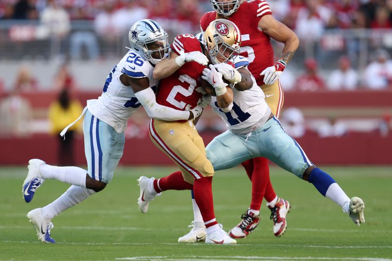 San Francisco 49ers running back Christian McCaffrey (23) runs against Dallas Cowboys cornerback DaRon Bland (26) and linebacker Micah Parsons (11) during the first half of an NFL football game in Santa Clara, Calif., Sunday, Oct. 8, 2023. (AP Photo/Jed Jacobsohn)