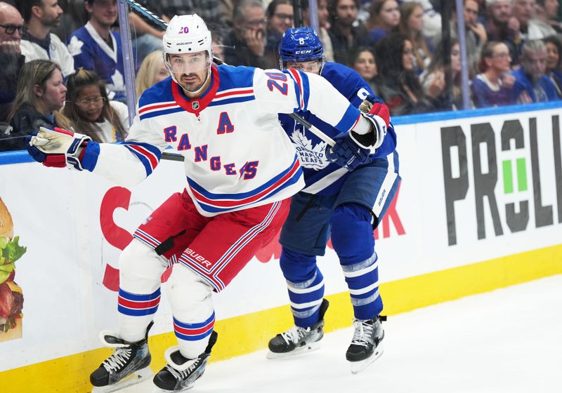 Oct 19, 2024; Toronto, Ontario, CAN; New York Rangers left wing Chris Kreider (20) battles along the boards with Toronto Maple Leafs defenseman Chris Tanev (8) during the second period at Scotiabank Arena. Mandatory Credit: Nick Turchiaro-Imagn Images