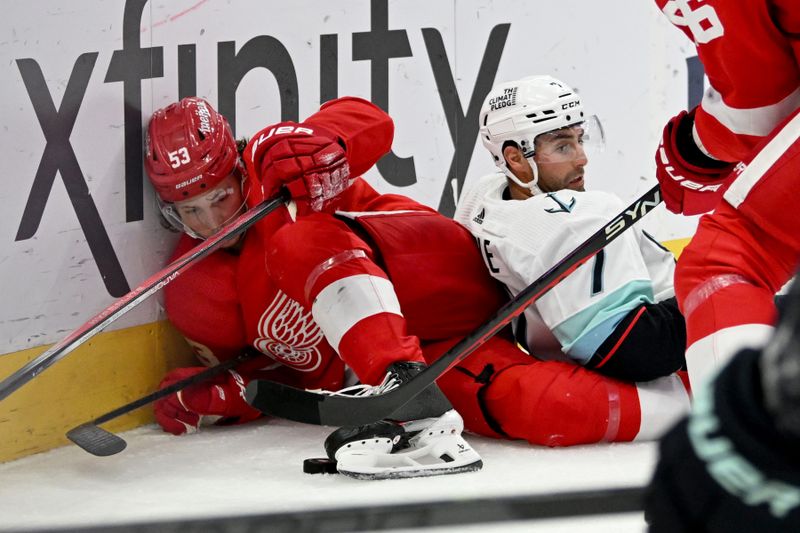 Oct 24, 2023; Detroit, Michigan, USA; Detroit Red Wings defenseman Moritz Seider (53) and Seattle Kraken right wing Jordan Eberle (7) fall onto the ice against the boards while fighting for the puck behind the Red Wings goal in the third period at Little Caesars Arena. Mandatory Credit: Lon Horwedel-USA TODAY Sports