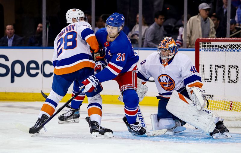 Sep 24, 2024; New York, New York, USA; New York Rangers left wing Chris Kreider (20) tries to deflect a shot while in between New York Islanders defenseman Alexander Romanov (28) and New York Islanders goalie Semyon Varlamov (40) during the first period at Madison Square Garden. Mandatory Credit: Danny Wild-Imagn Images