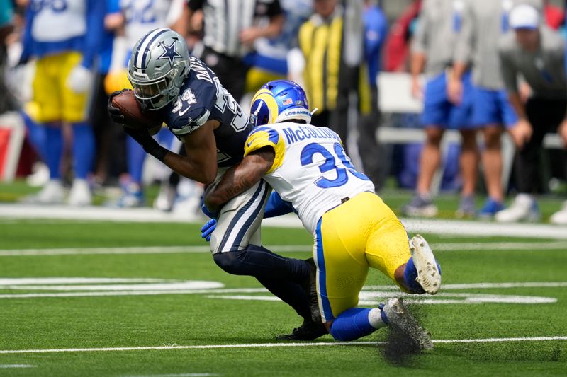 Dallas Cowboys running back Malik Davis (34) is stopped by Los Angeles Rams safety Jaylen McCollough (39) after catching a pass during the first half of a preseason NFL football game, Sunday, Aug. 11, 2024, in Inglewood, Calif. (AP Photo/Ryan Sun)