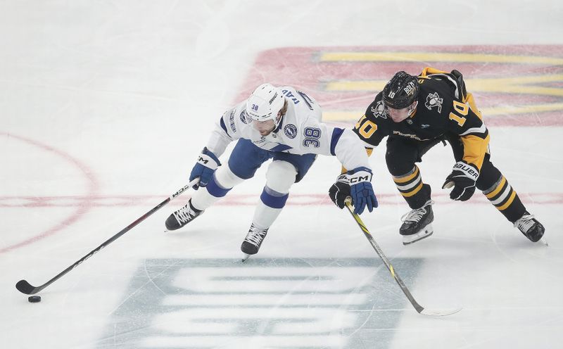 Nov 19, 2024; Pittsburgh, Pennsylvania, USA; Tampa Bay Lightning left wing Brandon Hagel (38) moves the puck against Pittsburgh Penguins left wing Drew O'Connor (10) during the second period at PPG Paints Arena. Mandatory Credit: Charles LeClaire-Imagn Images