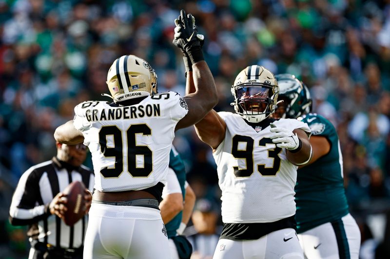 New Orleans Saints defensive tackle David Onyemata (93) and defensive end Carl Granderson (96) celebrate a sack of Philadelphia Eagles quarterback Gardner Minshew (10) during an NFL football game, Sunday, Jan. 1, 2023, in Philadelphia. (AP Photo/Rich Schultz)