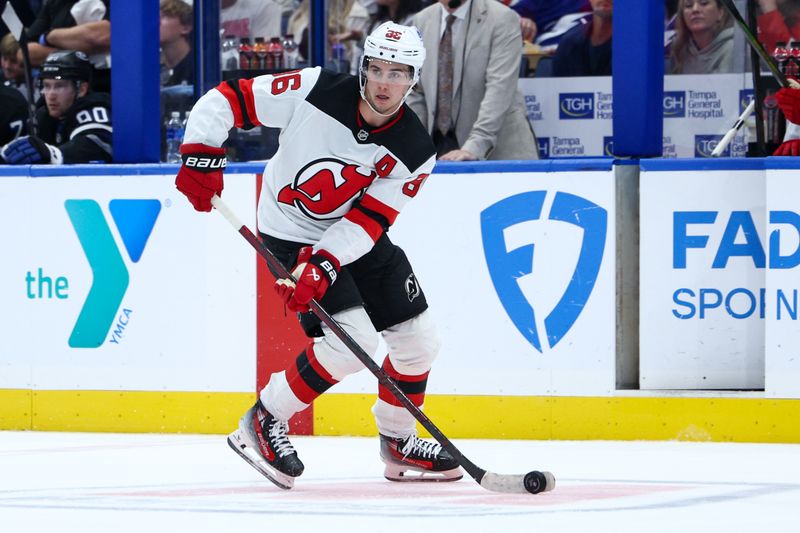 Nov 16, 2024; Tampa, Florida, USA; New Jersey Devils center Jack Hughes (86) controls the puck against the Tampa Bay Lightning in the second period at Amalie Arena. Mandatory Credit: Nathan Ray Seebeck-Imagn Images