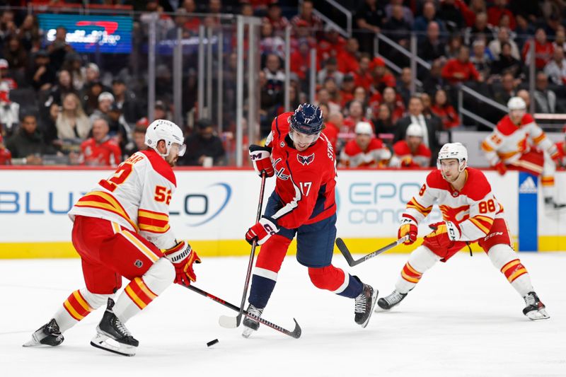 Oct 16, 2023; Washington, District of Columbia, USA; Washington Capitals center Dylan Strome (17) shoots the puck as Calgary Flames defenseman MacKenzie Weegar (52) and Calgary Flames left wing Andrew Mangiapane (88) defend in the third period at Capital One Arena. Mandatory Credit: Geoff Burke-USA TODAY Sports