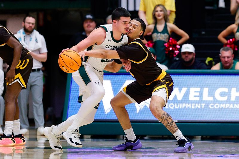 Feb 14, 2026; Fort Collins, Colorado, USA; Colorado State Rams forward Jevin Muniz (55) controls the ball under pressure from Wyoming Cowboys guard Khaden Bennett (3) in the first half at Moby Arena. Mandatory Credit: Isaiah J. Downing-Imagn Images