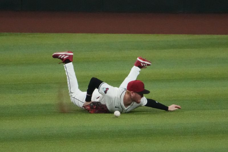 Sep 13, 2024; Phoenix, Arizona, USA; Arizona Diamondbacks outfielder Pavin Smith (26) is unable to make a diving catch against the Milwaukee Brewers during the fourth inning at Chase Field. Mandatory Credit: Joe Camporeale-Imagn Images