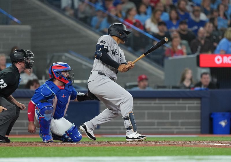 Jun 30, 2025; Toronto, Ontario, CAN; New York Yankees centre fielder Trent Grisham (12) hits a single against the Toronto Blue Jays during the fourth inning at Rogers Centre. Mandatory Credit: Nick Turchiaro-Imagn Images