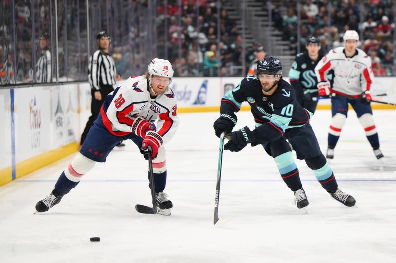 Jan 23, 2025; Seattle, Washington, USA; Washington Capitals defenseman Rasmus Sandin (38) and Seattle Kraken center Matty Beniers (10) chase the loose puck during the third period at Climate Pledge Arena. Mandatory Credit: Steven Bisig-Imagn Images