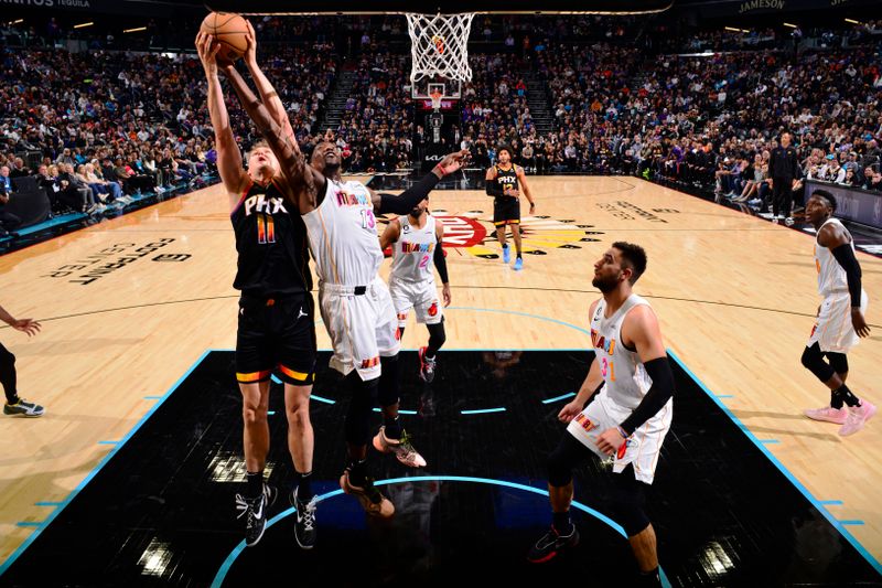 PHOENIX, AZ - JANUARY 6: Bam Adebayo #13 of the Miami Heat and Jock Landale #11 of the Phoenix Suns rebounds the ball during the game on January 6, 2023 at Footprint Center in Phoenix, Arizona. NOTE TO USER: User expressly acknowledges and agrees that, by downloading and or using this photograph, user is consenting to the terms and conditions of the Getty Images License Agreement. Mandatory Copyright Notice: Copyright 2022 NBAE (Photo by Barry Gossage/NBAE via Getty Images)