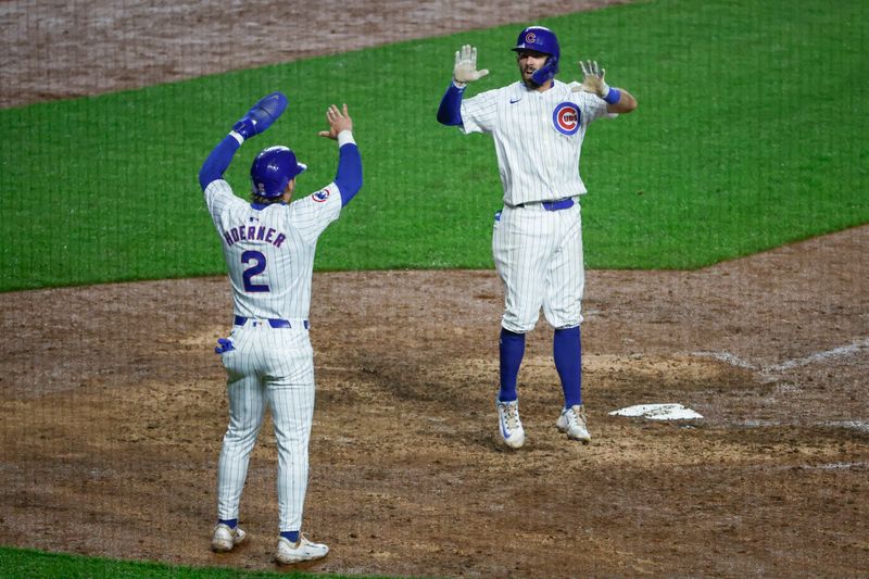 Jun 2, 2024; Chicago, Illinois, USA; Chicago Cubs shortstop Dansby Swanson (7) celebrates with second baseman Nico Hoerner (2) as he crosses home plate after hitting a two-run home run against the Cincinnati Reds during the eight inning at Wrigley Field. Mandatory Credit: Kamil Krzaczynski-USA TODAY Sports