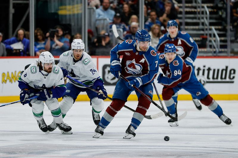 Apr 10, 2025; Denver, Colorado, USA; Colorado Avalanche defenseman Devon Toews (7) controls the puck ahead of Vancouver Canucks right wing Conor Garland (8) and center Pius Suter (24) in the second period at Ball Arena. Mandatory Credit: Isaiah J. Downing-Imagn Images