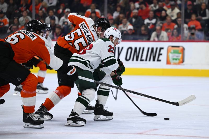 Oct 26, 2024; Philadelphia, Pennsylvania, USA; Minnesota Wild center Marco Rossi (23) pushes the puck past Philadelphia Flyers defenseman Rasmus Ristolainen (55) in the second period at Wells Fargo Center. Mandatory Credit: Kyle Ross-Imagn Images