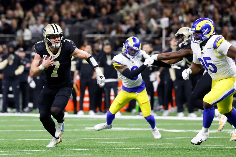 New Orleans Saints tight end Taysom Hill (7) runs past Los Angeles Rams defensive tackle Bobby Brown III (95) during the first half of an NFL football game Sunday, Dec. 1, 2024, in New Orleans. (AP Photo/Butch Dill)