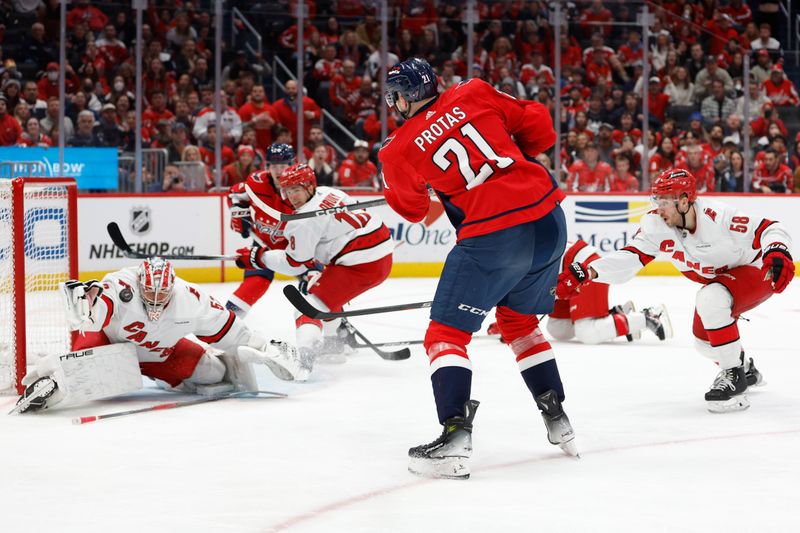 Jan 5, 2024; Washington, District of Columbia, USA; Carolina Hurricanes goaltender Pyotr Kochetkov (52) makes a save on Washington Capitals center Aliaksei Protas (21) in the third period at Capital One Arena. Mandatory Credit: Geoff Burke-USA TODAY Sports