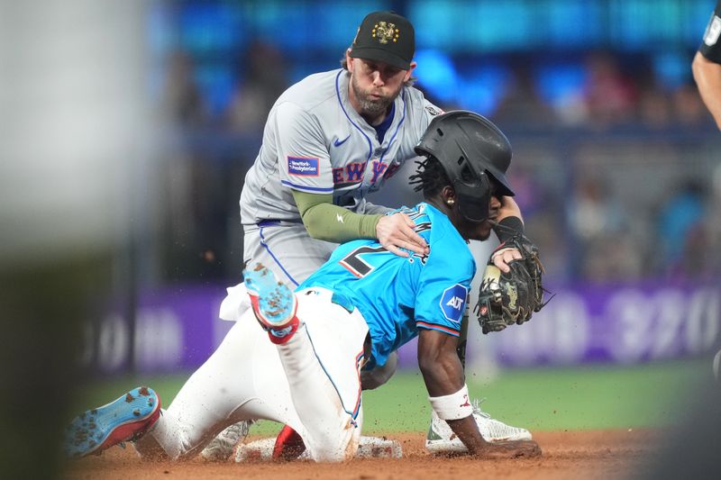 May 19, 2024; Miami, Florida, USA;  New York Mets second baseman Jeff McNeil (1) tags out Miami Marlins center fielder Jazz Chisholm Jr. (2) trying to steal second base in the seventh inning at loanDepot Park. Mandatory Credit: Jim Rassol-USA TODAY Sports