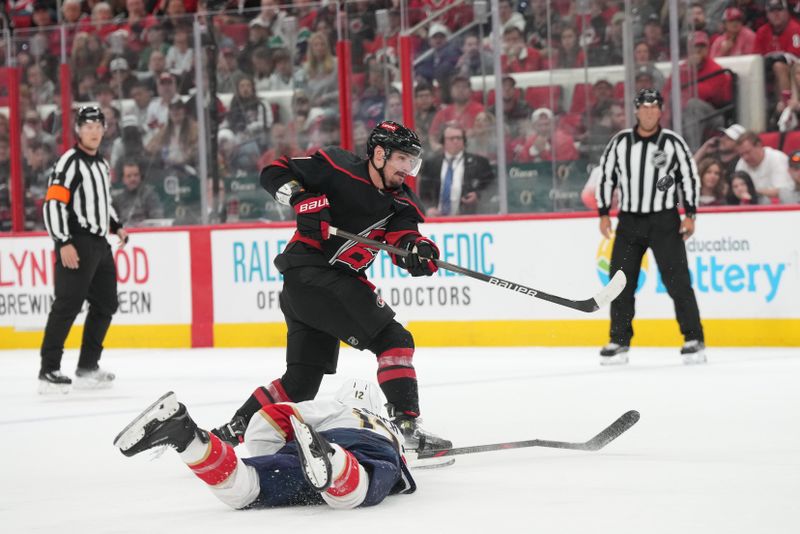 May 20, 2025; Raleigh, North Carolina, USA;  Florida Panthers forward Jonah Gadjovich (12) defends against a Carolina Hurricanes player during the third period in game one of the Eastern Conference Final of the 2025 Stanley Cup Playoffs at Lenovo Center. Mandatory Credit: James Guillory-Imagn Images