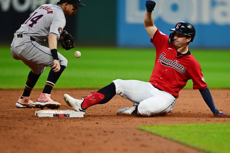Sep 28, 2024; Cleveland, Ohio, USA; Cleveland Guardians right fielder Will Brennan (17) slides into second with a double as Houston Astros left fielder Mauricio Dubon (14) gets the throw during the third inning at Progressive Field. Mandatory Credit: Ken Blaze-Imagn Images