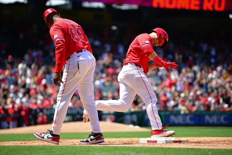 May 26, 2024; Anaheim, California, USA; Los Angeles Angels catcher Matt Thaiss (21) is greeted by first base coach Bo Porter (88) after hitting a two run home run against the Cleveland Guardians during the fifth inning at Angel Stadium. Mandatory Credit: Gary A. Vasquez-USA TODAY Sports