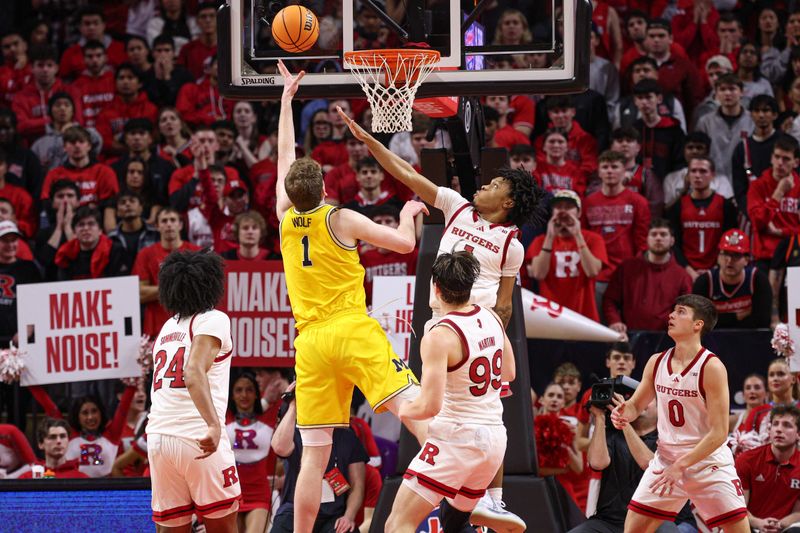 Feb 1, 2025; Piscataway, New Jersey, USA; Michigan Wolverines center Danny Wolf (1) goes to the basket asRutgers Scarlet Knights guard Jamichael Davis (1) defends during the second half at Jersey Mike's Arena. Mandatory Credit: Vincent Carchietta-Imagn Images