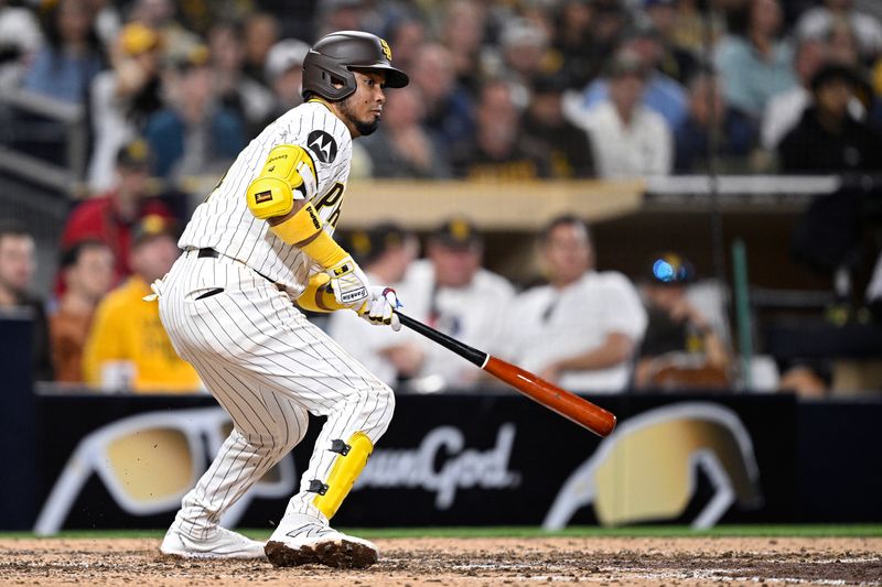 May 13, 2024; San Diego, California, USA; San Diego Padres second baseman Luis Arraez (4) hits an RBI single against the Colorado Rockies during the seventh inning at Petco Park. Mandatory Credit: Orlando Ramirez-USA TODAY Sports